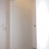 bílá vestavěná skříň do menšího prostoru chodby se systémem otevírání na zmáčknutí