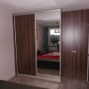 dvoudílná tmavá ložnicová vestavěná skříň s křídlovými i posuvnými dveřmi se zrcadlem