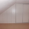 Bílá podkrovní skříň do šikminy, posuvné dveře, zkosená část s pantovými dveřmi